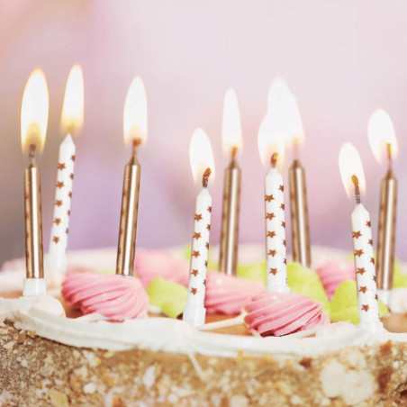 Candele semplici e stelle dorate su una torta