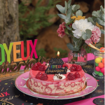 Candelina multicolore di buon compleanno su una torta