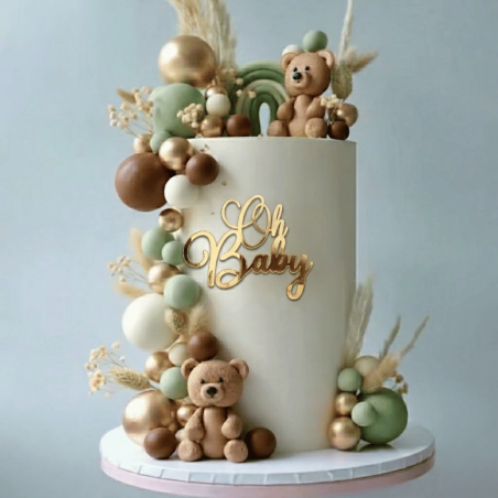 Torta per baby shower con decorazione a sfera dorata e tonalità naturali intorno alla torta