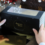 Tronchetto di Natale nero con decorazioni dorate, buone feste